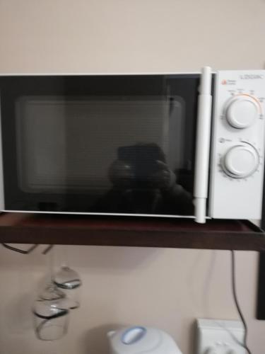 a microwave oven sitting on a shelf at KIHARA GUESTHOUSE in Bethlehem