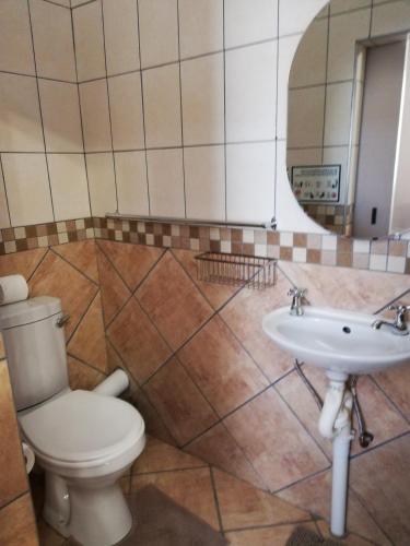a bathroom with a toilet and a sink at KIHARA GUESTHOUSE in Bethlehem