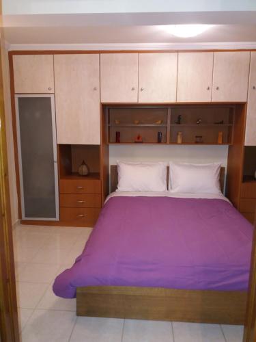a bedroom with a large bed with purple sheets at Marmari vacation flat in Marmari