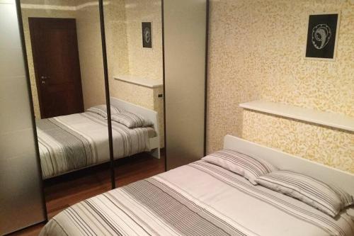a bedroom with two beds and a mirror at Casetta Helena in Trieste