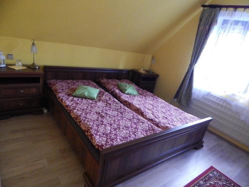 a bedroom with a wooden bed with two pillows on it at Penzion Dřevěnka in Osečná