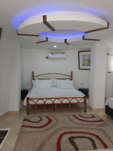 a bedroom with a bed with a blue ceiling at Eco-Hotel Villa Elina in Ríohacha