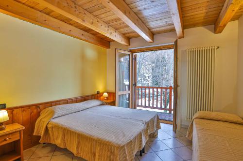 sypialnia z łóżkiem i dużym oknem w obiekcie Apartments La Gran Becca w mieście Antey-Saint-André