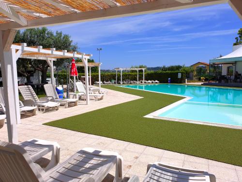 une piscine avec des chaises longues et une piscine dans l'établissement Posto Nove Country House, à Corropoli