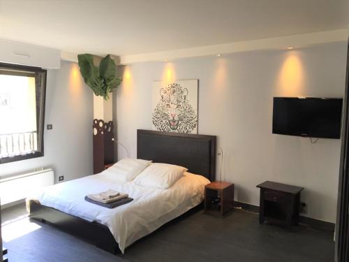 Schlafzimmer mit einem Bett und einem Flachbild-TV in der Unterkunft PEACE&LOFT: JACUZZI & TERRASSE in Versailles
