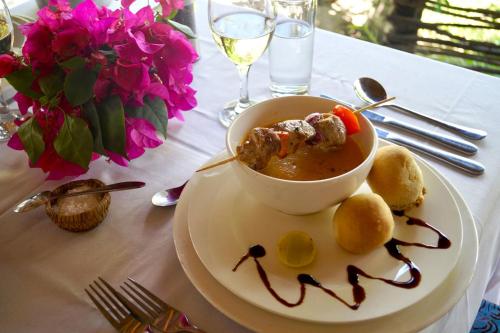 a bowl of soup on a plate on a table at Laguna Palace Zanzibar in Michamvi