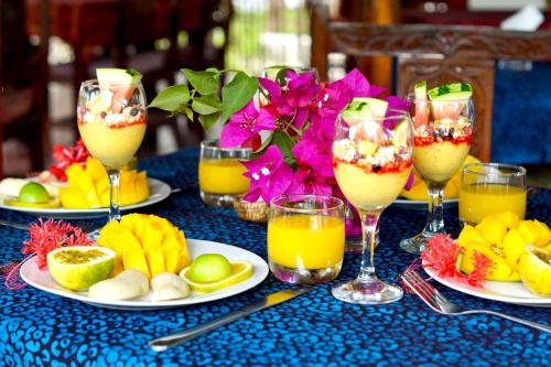 una mesa con platos de fruta y vasos de zumo en Laguna Palace Zanzibar, en Michamvi