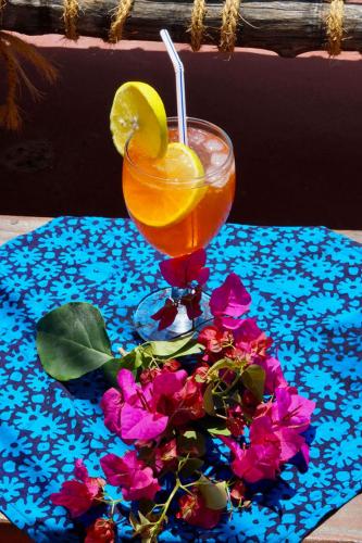 a drink with a lemon and flowers on a table at Laguna Palace Zanzibar in Michamvi