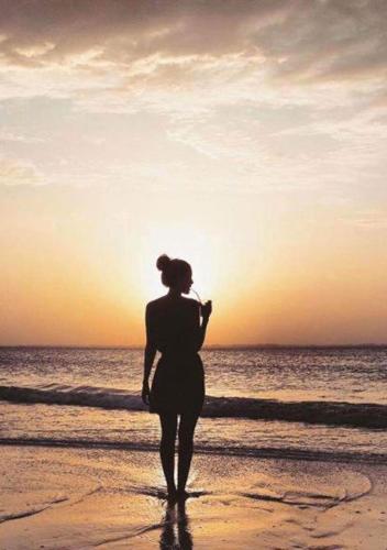 a woman standing on the beach watching the sunset at Laguna Palace Zanzibar in Michamvi