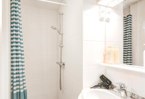 ein Bad mit einer Dusche und einem Waschbecken in der Unterkunft Cute Cozy Apartment in Historic Center in Antwerpen