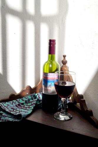 a bottle of wine and a glass of red wine at Laguna Palace Zanzibar in Michamvi