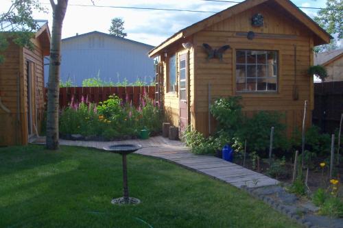 un patio con una casa y una parrilla en el césped en Cabine, Home Sweet Home, en Whitehorse