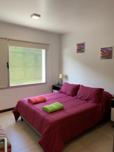 1 cama grande de color púrpura en un dormitorio con ventana en Departamento en Casa Histórica 17 - Andarlibre en San Martín de los Andes