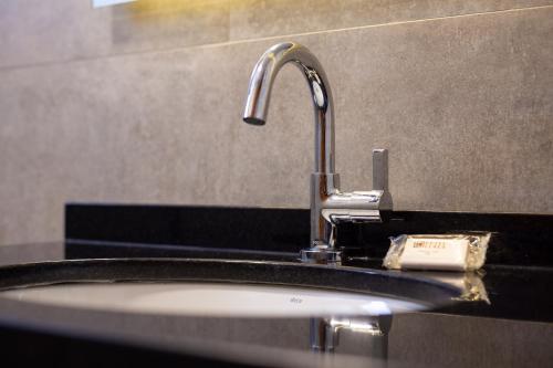 a bathroom sink with a faucet on a counter at Hotel Lunes in São José