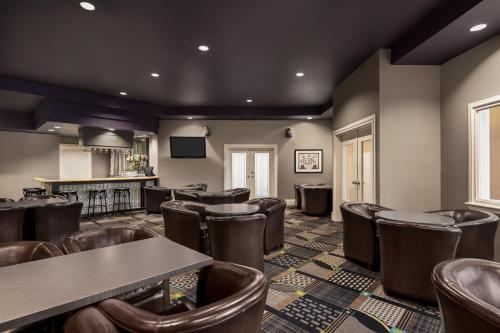 a bar with brown chairs and tables in a room at Royal Hotel Regina, Trademark Collection by Wyndham in Regina