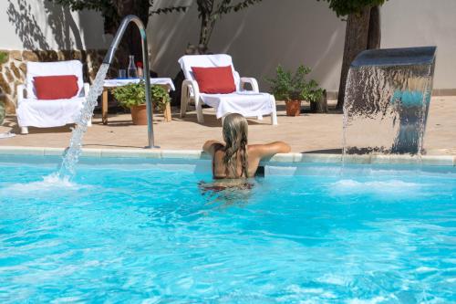 a woman in a swimming pool with a fountain at Villa María in La Laguna