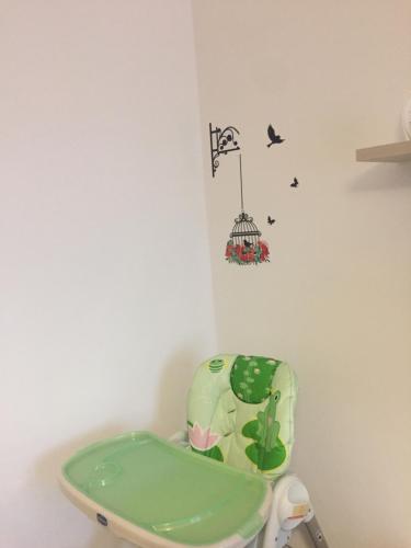 a bathroom with a green toilet with a bird cage on the wall at App sul lungomare in San Benedetto del Tronto