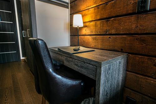 a wooden desk with a lamp and a chair at Eriksgårdens Fjällhotell in Funäsdalen