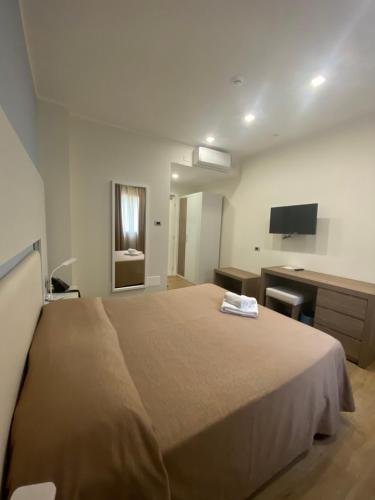 una camera con un grande letto e una scrivania di La Porta del Sole Hotel & Village a San Ferdinando