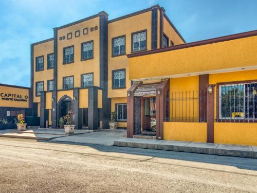 un gran edificio amarillo en una calle en Monte Salerno Hotel & Suites, en Montemorelos