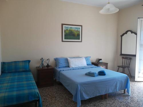 a bedroom with two beds with blue sheets at Casa di Angela in Syracuse