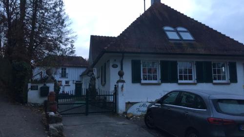 a white house with a car parked in front of it at Altes Forsthaus Waldenbuch / Bei der Messe Stuttgart in Waldenbuch