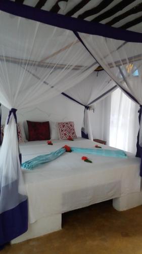 a bedroom with a white bed in a tent at Laguna Palace Zanzibar in Michamvi