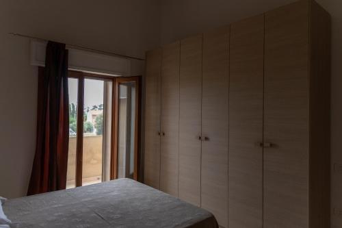 a bedroom with a bed and a window at Case Fiorite in Riola Sardo