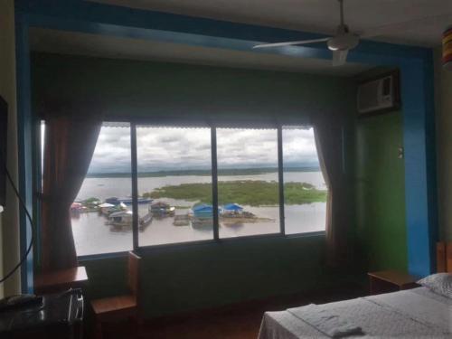 a bedroom with a large window with a view of a marina at Amazon Dream Hostel with AC and Starlink in Iquitos