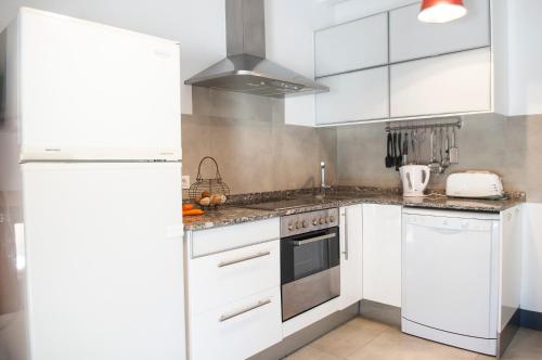 a kitchen with white cabinets and a refrigerator at Finca Pessal in Caʼs Concos