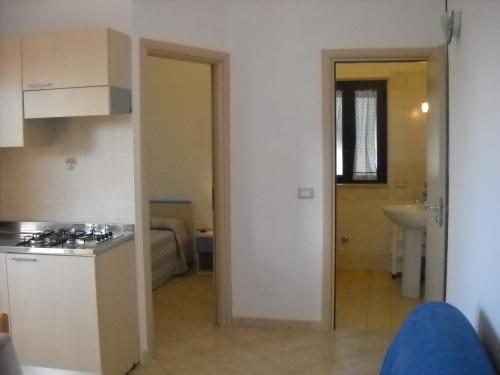 a kitchen with a stove and a sink in a room at Zagare Residence in Rodi Garganico