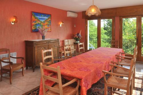 a dining room with a red table and chairs at Logis Hôtel & Restaurant Aux Tauzins in Montfort-en-Chalosse