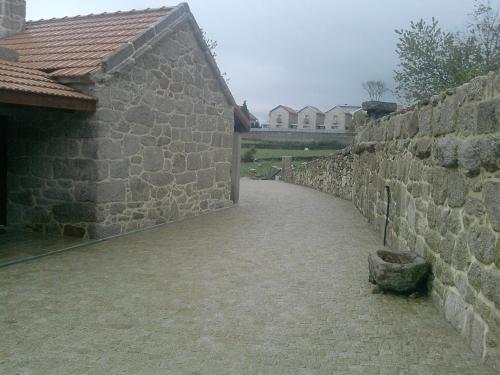 a stone wall with a walkway next to a building at Casa Fonte Do Laboreiro in Castro Laboreiro