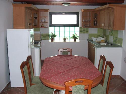 a kitchen with a table and a table and a refrigerator at Sissy Vendégház in Mórahalom