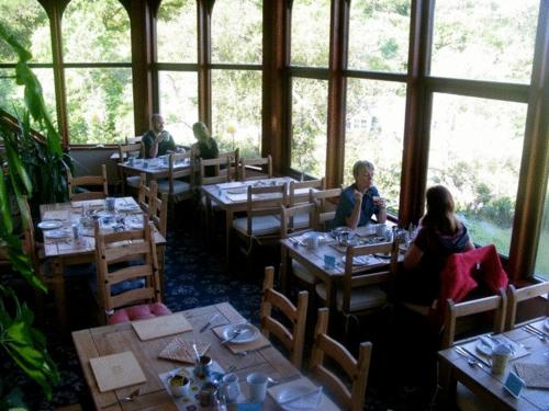 eine Gruppe von Personen, die in einem Restaurant an Tischen sitzen in der Unterkunft Gairloch Highland Lodge in Gairloch