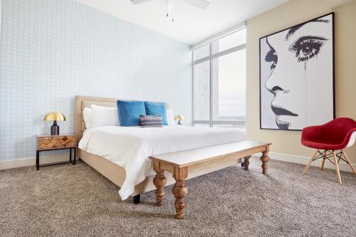 a bedroom with a large bed and a red chair at Sonder at The Catherine in Austin