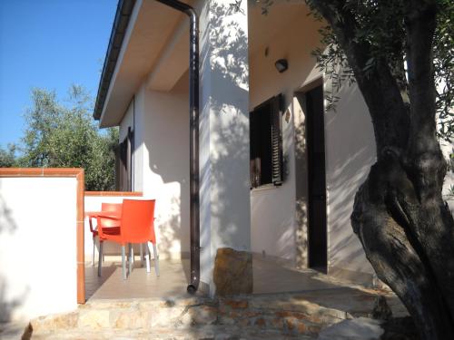 an open door to a house with a table and a tree at Zagare Residence in Rodi Garganico