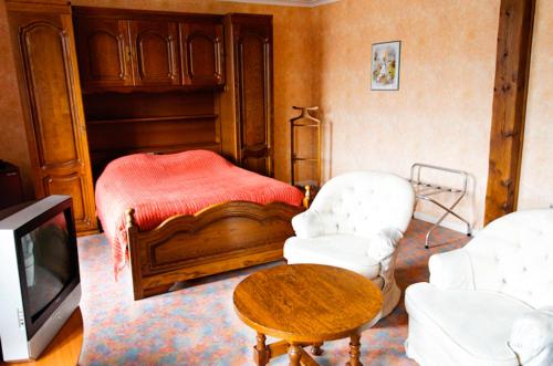a living room with a bed and a table and chairs at Auberge d'Alsace Hotel de France in Bouillon