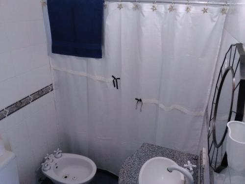 a bathroom with a sink and a toilet and a shower curtain at La historica in Concepción del Uruguay