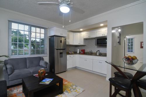 eine Küche und ein Wohnzimmer mit einem Sofa und einem Tisch in der Unterkunft Choose To Be Happy at Gardens of Blissett GOB#1 & GOB #2 - Two Bedroom Apartments in Kingston