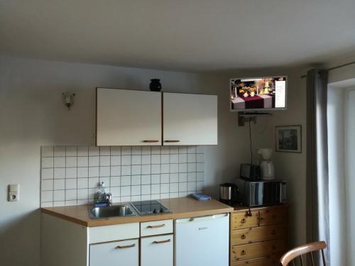 a kitchen with white cabinets and a sink at Apartment Waldhaus Opitz in Zell am See