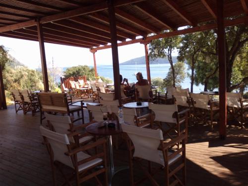 a restaurant with tables and chairs and a view of the ocean at Mikros Gialos Apartments in Mikros Gialos