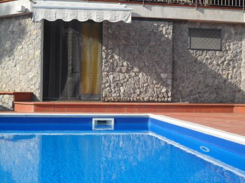 a blue swimming pool in front of a building at Lady Food Location in Cava deʼ Tirreni