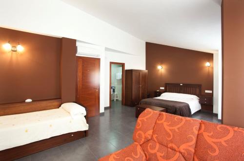 a hotel room with two beds and a couch at Casa Rural Casole in Castalla