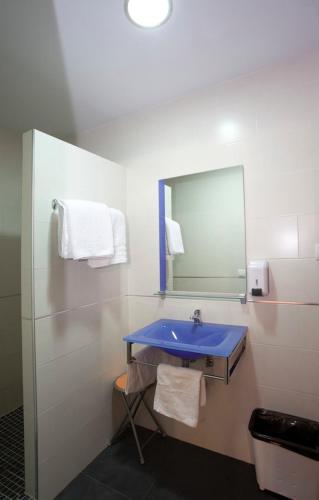 a bathroom with a blue sink and a mirror at Casa Rural Casole in Castalla