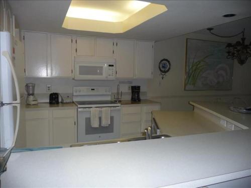 a kitchen with a stove and a microwave at Suntide I Condos W107 in South Padre Island