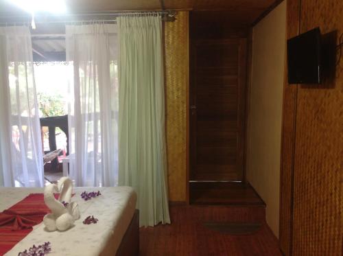 a bedroom with a bed with two stuffed animals on it at Ruan Mai Naiyang Beach Resort in Nai Yang Beach