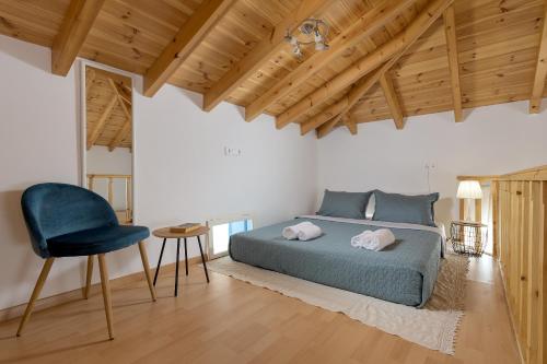 a bedroom with a bed and a blue chair at Anastasia house in Halki