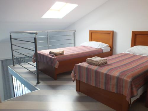 a bedroom with two beds and a stair case at Residence Lavanda in Umag