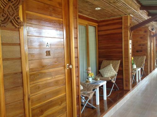 a room with a door and a table and chairs at Ruan Mai Naiyang Beach Resort in Nai Yang Beach